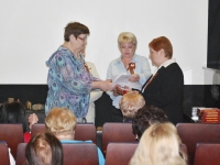 Сотрудники архива поздравляют бывшего директора архива Л.П.Запрягаеву (справа) с 70-летием Победы