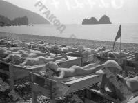 Дети пионерского лагеря «Артек» принимают солнечные ванны на пляже у моря.